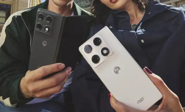 Dwie osoby trzymają telefony Motorola Razr fold. Jeden czarny, złożony, drugi biały, rozłożony.