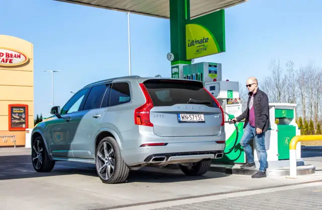Mężczyzna tankuje szare Volvo XC60. Zastanawiasz się, ile spala Volvo XC60? Sprawdźmy!