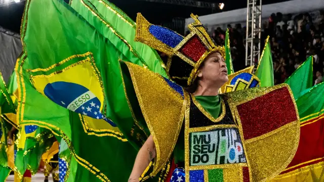 Tancerka w barwnym stroju z flagą Brazylii na tle tłumu podczas karnawału w Rio.