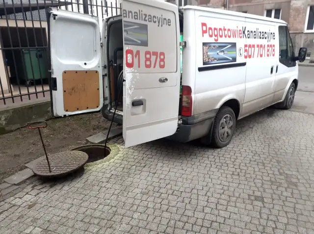 Biały van z napisem "Pogotowie Kanalizacyjne" i numerem telefonu 507 701 878, gotowy do pracy jako hydraulik w Nowym Dworze Mazowieckim.