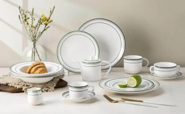Elegancka zastawa stołowa z porcelany i kamionki, z subtelnymi czarnymi i zielonymi paskami, idealna na śniadanie.