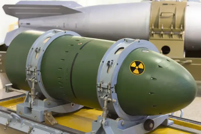 Zielona bomba nuklearna z symbolem promieniowania, gotowa do użycia. W tle widać inną, większą bombę.