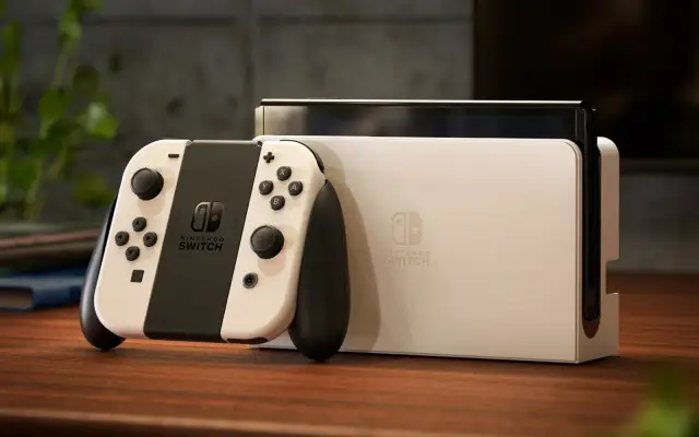 Biały kontroler i konsola Nintendo Switch, gotowe do gry. To jest właśnie ten słynny switch, co to potrafi!