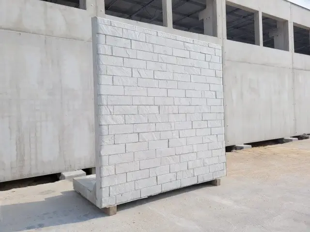 Gotowy do montażu mur oporowy betonowy z fakturą cegły. Solidna konstrukcja na placu budowy.