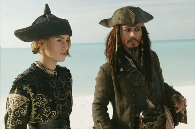 Elizabeth Swann i Kapitan Jack Sparrow, gwiazdy "Piraci z Karaibów", stoją na plaży.