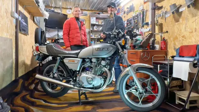 Dwóch mężczyzn w garażu obok klasycznego motocykla Suzuki GS400.