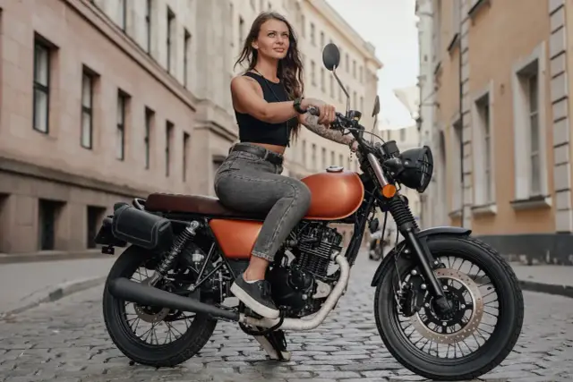 Kobieta na motocyklu 125cc, gotowa na jazdę po mieście. Stylowa, pewna siebie, z wolnością w oczach.