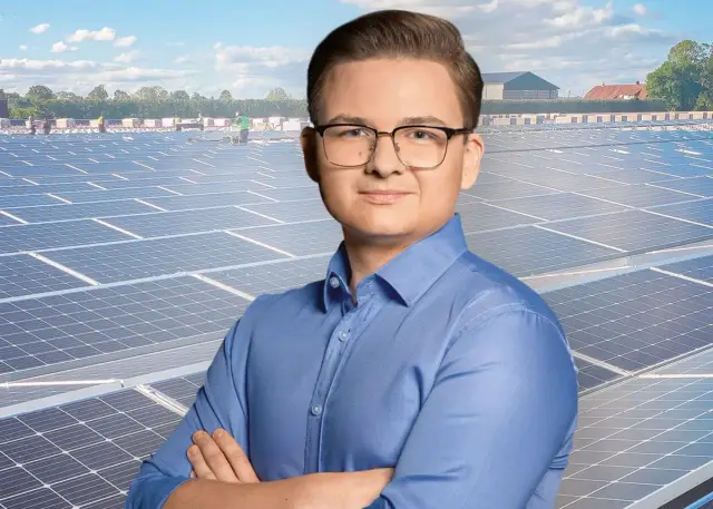 Mężczyzna w okularach na tle farmy fotowoltaicznej. Jego opinie o energii odnawialnej budzą respekt.