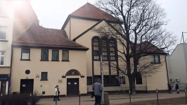 Synagoga w Gdańsku, z charakterystycznymi oknami i menora przed budynkiem.