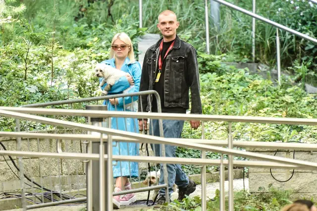 Margaret z mężem spacerują z psami po zielonym parku.