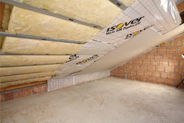 Ocieplenie poddasza folią paroizolacyjną Isover Vario KM Duplex UV. Wełna mineralna ułożona na stelażu, gotowa do dalszych prac.