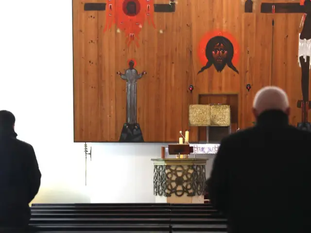 Wierni w kościele modlą się przed ikonami. Dyskusja o podatek na kościół trwa.