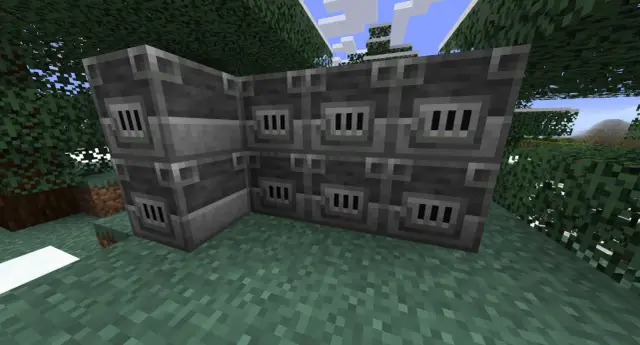 W Minecraft zbudowano duży piec hutniczy z kamienia. Otaczają go drzewa i trawa.
