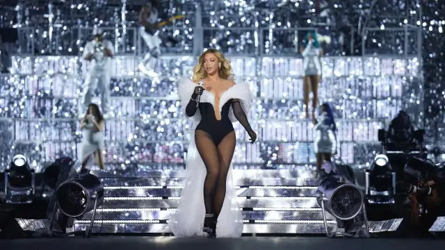 Beyoncé w olśniewającym stroju na scenie, podczas spektakularnego koncertu. Tysiące świateł tworzy magiczną atmosferę.