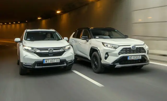Dwa białe SUV-y, Honda CR-V i Toyota RAV4, jadą tunelem.