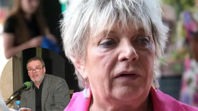 Dorota Stalińska z mężem. Mężczyzna w okularach przemawia przy mikrofonie, obok kobiety z siwymi włosami.