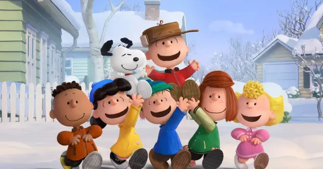 Grupa przyjaciół z Fistaszków, w tym Charlie Brown i Snoopy, cieszy się zimową zabawą na śniegu.