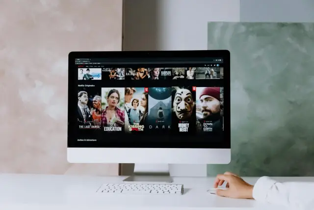 Komputer wyświetla Netflix, pokazując popularne seriale i filmy. To właśnie jest streaming – oglądanie treści online.