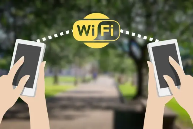 Dwie dłonie trzymają smartfony, między którymi widoczny jest symbol Wi-Fi. Połączenie **wifi direct** umożliwia szybką wymianę danych.