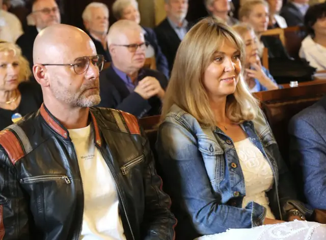 Mąż Ewy Wachowicz, w skórzanej kurtce, siedzi obok niej w pierwszym rzędzie.