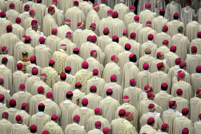 Tłum duchownych w białych szatach i różowych biretach, przypominający scenę z Soboru Watykańskiego II.