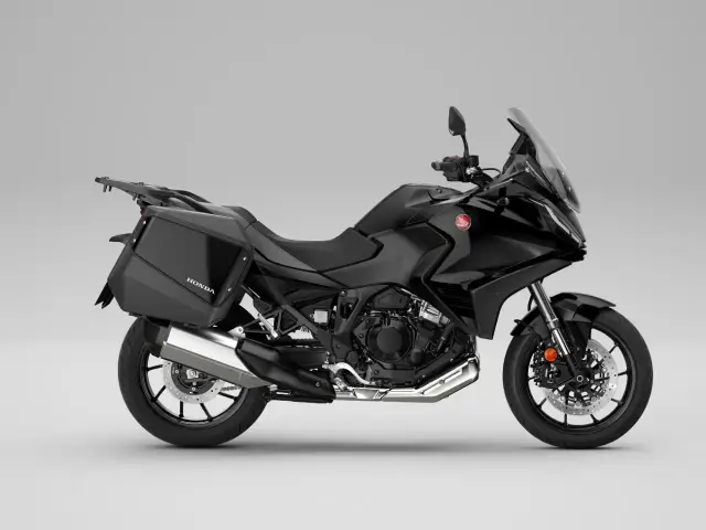 Czarny motocykl Honda turystyk z kuframi, gotowy na dalekie podróże.