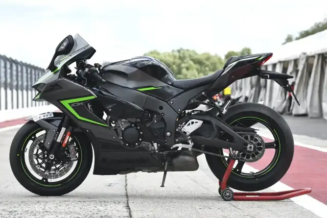 Czarny motocykl Kawasaki ZX-10R na stojaku. Poznaj jego imponujące kawasaki zx-10r dane techniczne i poczuj moc.