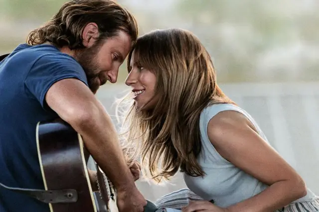 Bradley Cooper i Lady Gaga, narodziny gwiazdy obsada, w romantycznym uścisku z gitarą.
