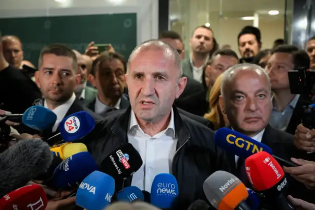 Mężczyzna przemawia do mediów, otoczony przez mikrofony. Pytanie "czy w Bułgarii jest bezpiecznie" nabiera tu szczególnego znaczenia.