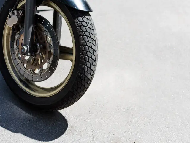 Przednia opona motocyklowa z tarczą hamulcową, gotowa do testu opon motocyklowych na asfalcie.