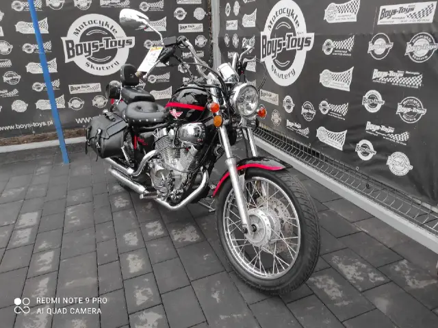 Czarny motocykl Lifan 250 z czerwonymi akcentami i sakwami, gotowy na przygodę.