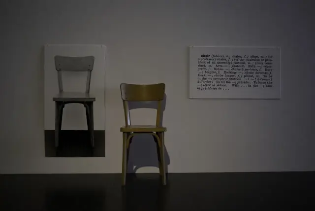 Dwa krzesła i fragment słownika definiujący słowo "chair" – to przykład konceptualizmu, gdzie idea jest ważniejsza od formy.