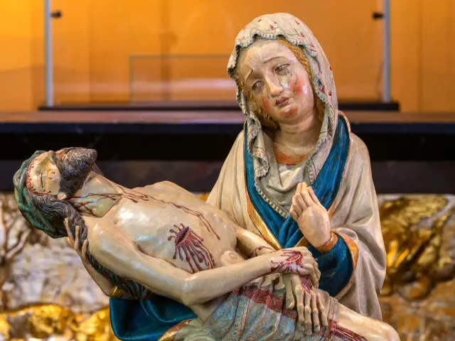 Pieta: Matka Boska trzyma na rękach martwe ciało Jezusa, jej twarz wyraża głęboki ból i cierpienie.