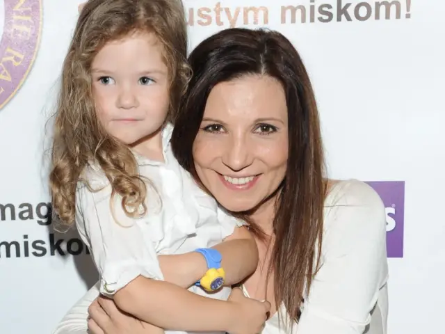 Magda z córką, uśmiechnięte, w białych koszulach. Dzieciństwo i macierzyństwo w obiektywie.