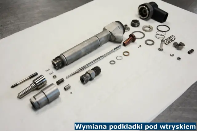 Rozłożony wtryskiwacz i jego części, w tym podkładka pod wtrysk, gotowe do wymiany.