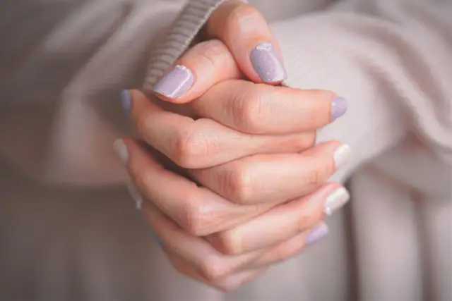 Delikatne paznokcie na komunie wzory: pastelowy fiolet i biel z subtelnymi zdobieniami.