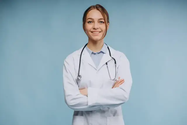 Uśmiechnięta lekarka w białym kitlu ze stetoskopem, zastanawia się, ile zarabia psychiatra.