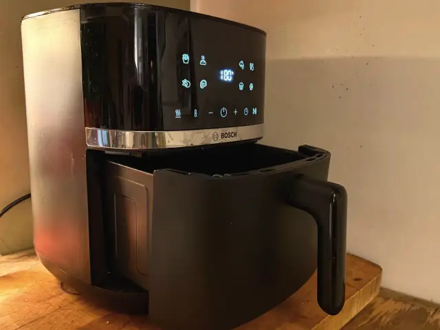 Czarny air fryer Bosch z wysuniętą szufladą. Dowiedz się, jak usunąć zapach spalenizny z air fryera po pierwszym użyciu.