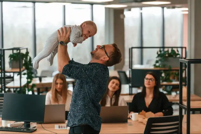 Ojciec podrzuca dziecko w biurze, podczas gdy koleżanki pracują. Czy urlop wychowawczy wlicza się do stażu pracy?