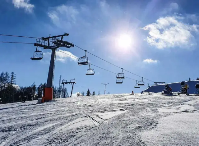 Wyciąg krzesełkowy i armatki śnieżne na stoku. Polańczyk atrakcje zimą czekają na narciarzy i snowboardzistów.