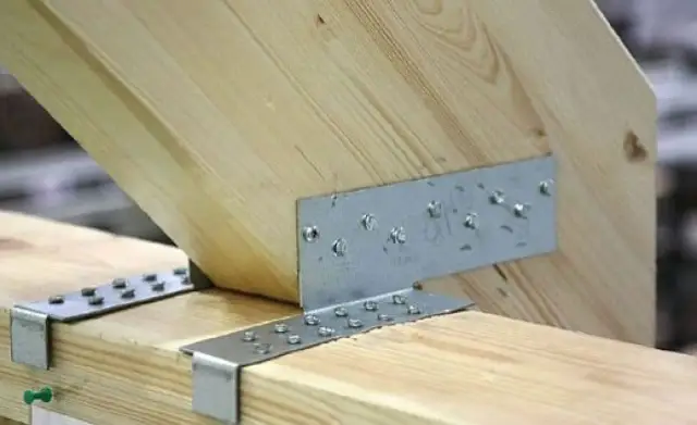 Solidne łączenie desek na zakładkę za pomocą metalowych kątowników i wkrętów. Konstrukcja drewniana zyskuje stabilność.
