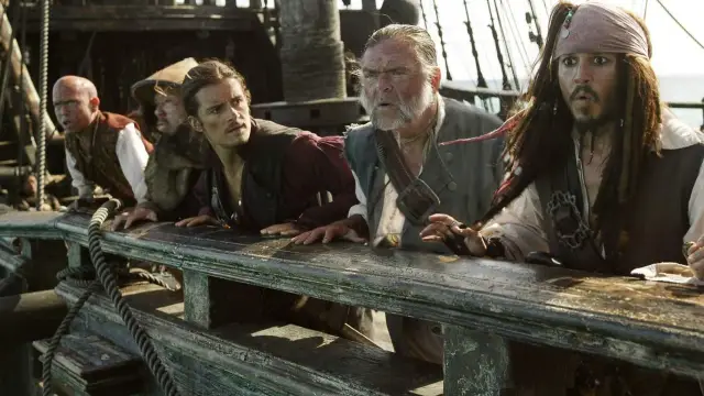 Kapitan Jack Sparrow i jego załoga z filmów "Piraci z Karaibów" na pokładzie statku, wyglądają na zaniepokojonych.