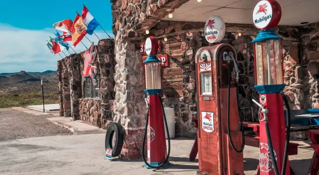 Stare dystrybutory paliwa Mobilgas i flagi narodowe przyciągają wzrok, zapraszając do odkrywania **route 66 atrakcje**.