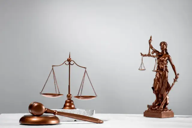 Młotek sędziowski, waga sprawiedliwości i Temida. Dowiedz się, jak uniknąć egzekucji z nieruchomości i walczyć o swoje prawa.