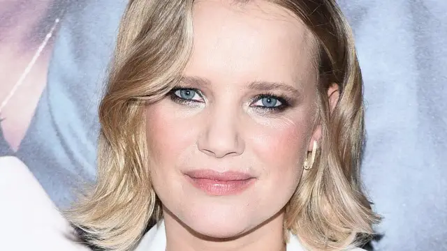 Joanna aktorka z błękitnymi oczami i blond włosami, w złotej kolczyku.