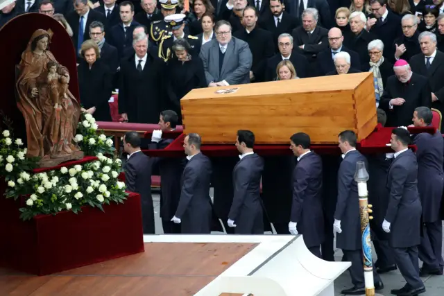 Uroczystość pogrzebowa. Papież Franciszek w otoczeniu dostojników żegna zmarłego.