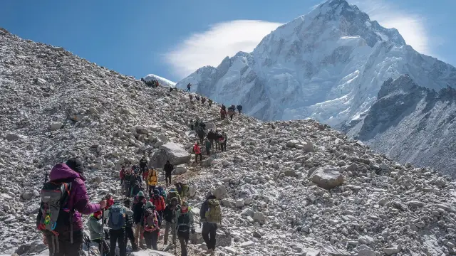 Tłum turystów na kamienistym zboczu Mount Everestu. Zastanawiasz się, ile kosztuje wejście na Mount Everest? To wyprawa życia!