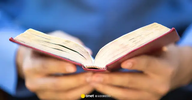 Dłonie trzymają otwartą księgę, być może zawierającą 10 przykazań bożych dekalog.