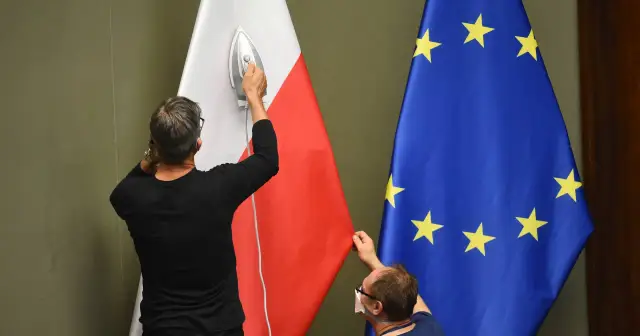 Dwaj mężczyźni przygotowują flagi Polski i UE. Jeden prasuje polską flagę, drugi poprawia unijną. Czy to zapowiedź polexitu?