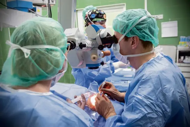 Chirurg wykonuje zabieg okulistyczny, być może w celu leczenia powikłań po operacji jaskry.